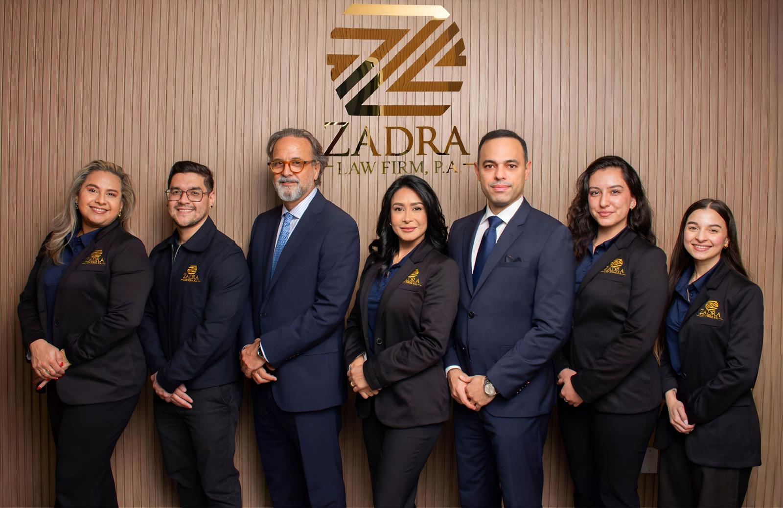Equipo de Zadra Law Firm, P.A. frente al logotipo de la firma
