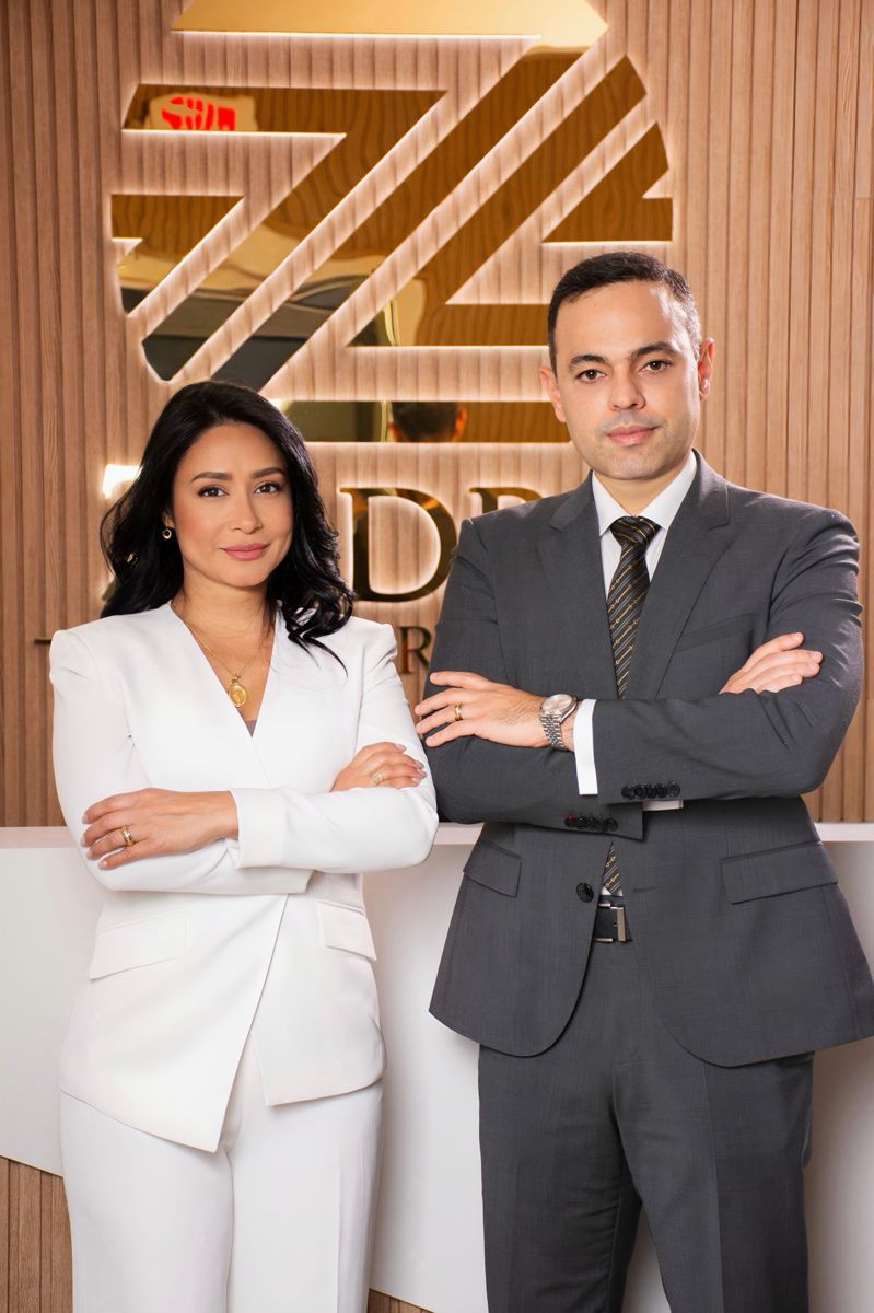 Integrantes de Zadra Law Firm, P.A. frente al logotipo de la firma